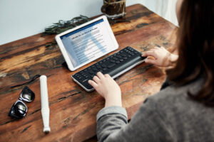 mulher utiliando a linha braille conectada a um tablet