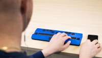 Jovem teclando no computador active braille